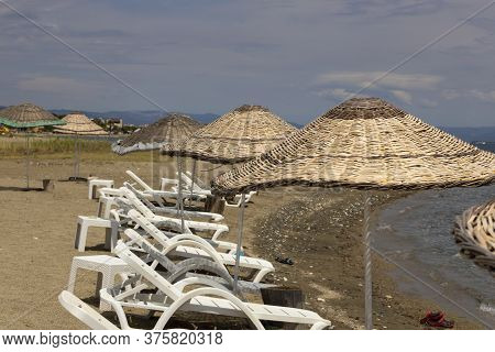 Sun Beds And Umbrellas By The Sea.