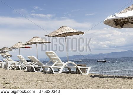Sun Beds And Umbrellas By The Sea.