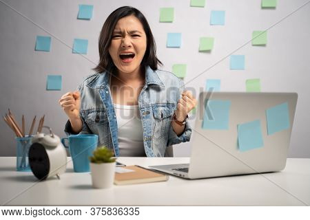 Asian Woman Angry Working On A Laptop And Shouting At Home Office. Wfh. Work From Home. Prevention C