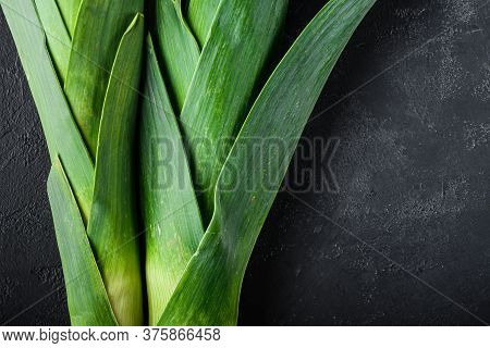 Organic Green Leek Onion On Black Textured Background, Top View With Space For Text.