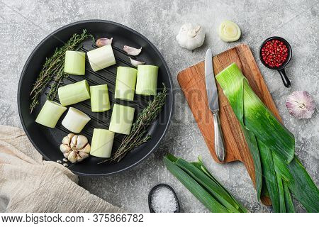 Raw Braised Leek Sultan On Grill Pan Uncooked With Herbs Ingredients  , On  Grey Textured Background