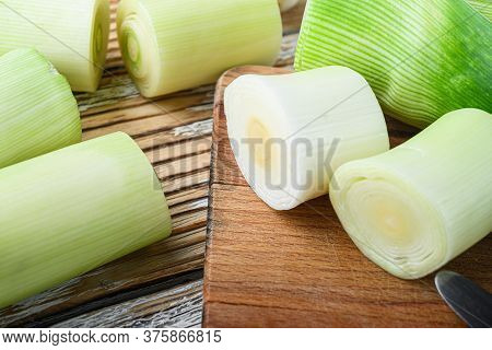 Green Chopped Leek Sultan On Choppong Board Over White Wood Table Side View Selective Focus.