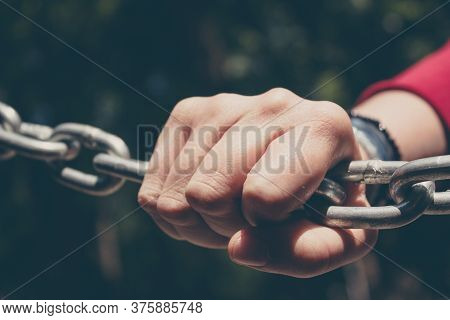 Young Hand On A Stainless Steel Chain. Youth Issues Concept. Conceptual Image