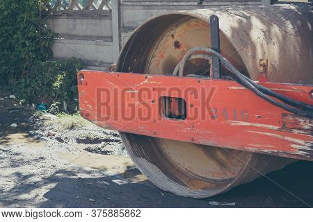 Closeup To An Orange Roller Compactor's Cylinder Wheel