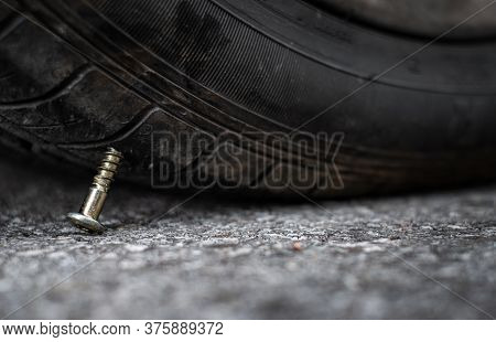 Close Up Button Head Needle Metal Screw Nail Stuck To Puncture Into Wheel Tire On The Road