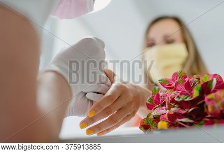 Customer woman in nail art studio wearing a protective face mask