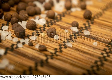 Fragrant Black Pepper And Coarse Sea Salt In Bulk On A Reed Mat. Close Up.