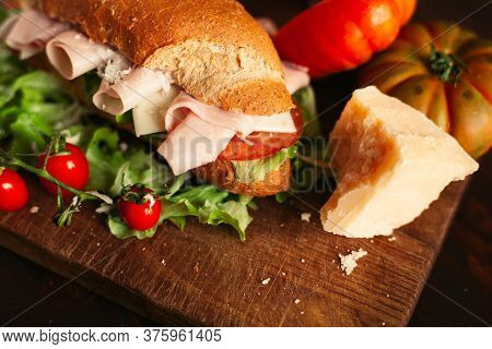 Traditional Italian Sandwich With Cheese, Ham, Salad, Tomatoes And Parmesan On Wooden Background, Se