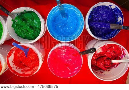Top View, Colorful Fabric Printing Inks In White Buckets.\rstirring The Ink For Multicolored Tee Shi