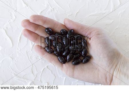Medication Or Supplement Capsules, Calanus Oil Capsules In A Womans Hand