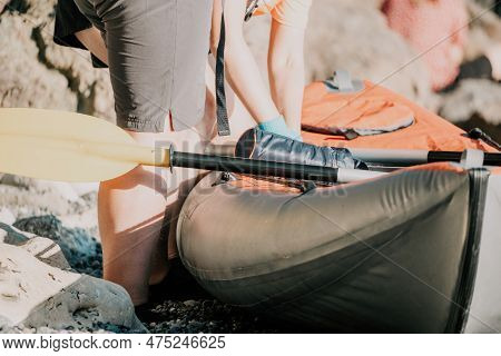 Happy Couple Kayaks In An Inflatable Kayak On The Sea At Sunset. Couple Kanoeing In The Sea Near The