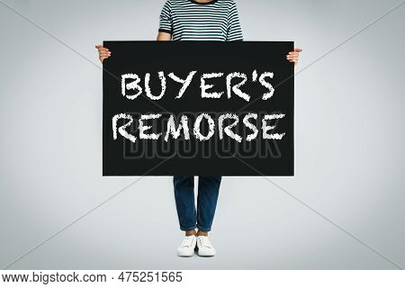 Woman Holding Poster With Text Buyer's Remorse On Light Grey Background, Closeup