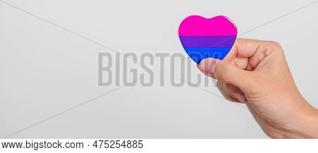 Bisexuality Celebrate Day And Lgbt Pride Month,  Lgbtq+ Or Lgbtqia+ Concept. Hand Holding Purple, Pi