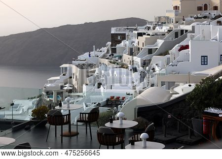 Imerovigli, Santorini, Greece - July 1, 2021: Whitewashed Houses With Terraces And Pools And A Beaut