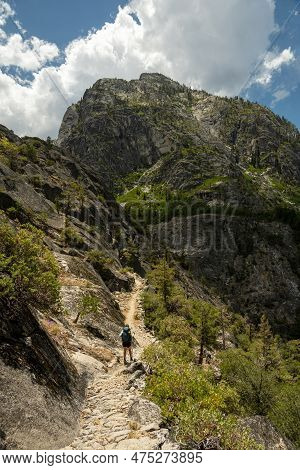 Woman Treks Along The Grand Canyon Of The Tuolmne With Mountains In Front Of Her In Summer