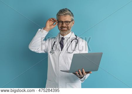 Middle Aged European Doctor Holding Computer Laptop