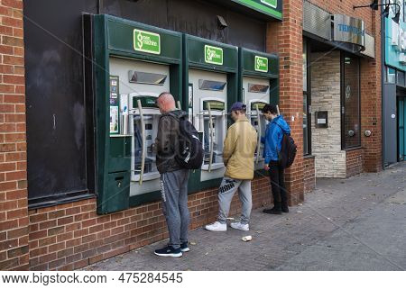 Toronto, Canada - 25 October 2022: People Standing Outside A Bank Redrawing Money With Their Bank Ca