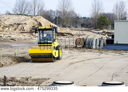 Construction Site With Underground Pipeline Reinforced Concrete Wells, Yellow Road Roller And High V