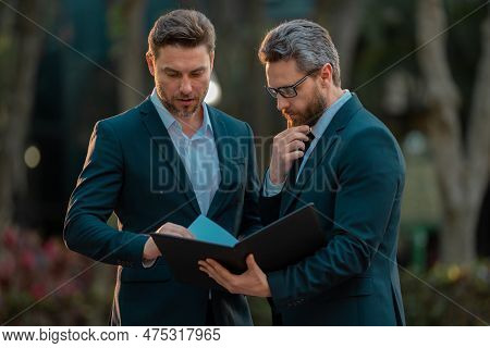 Colleagues In Suit Talking Outdoor. Two Businessmen Discussing Outdoor. Two Business People Talk Pro