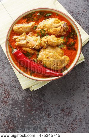 Spicy Indian Malvani Chicken Curry Closeup On The Bowl On The Table. Vertical Top View From Above