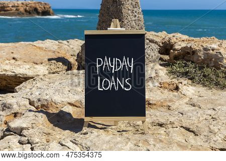 Payday Loans Symbol. Concept Words Payday Loans On Beautiful Black Chalk Blackboard. Beautiful Stone