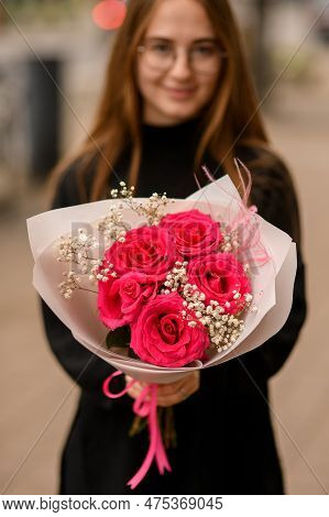 Woman Holding Luxury Composition Of Fresh Red Roses, White Gypsofila And Pink Feathers