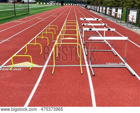 Thee Different Styles Of Training And Racing Hurdles In Lanes On A Red Track Ready For Strength And 
