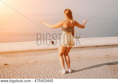 Woman Summer Dance. Silhouette Of A Happy Woman Who Dances, Spins And Raises Her Hands To The Sky. A
