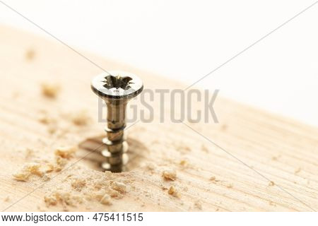 Partially Screwed Threaded Screw On A Piece Of Wood. Copy Space