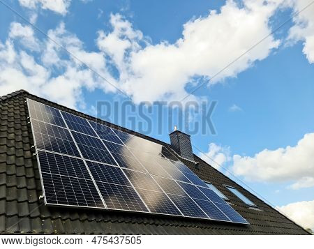 Solar Panels Producing Clean Energy On A Roof Of A Residential House
