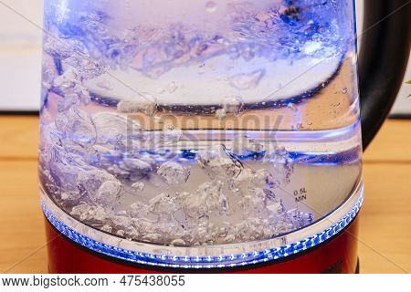 Red Modern Boiling Glass Electric Kettle Close-up With Bubbling Water