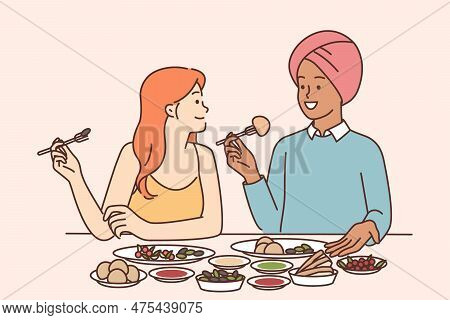 Indian Man And Caucasian Woman Are Sitting At Dinner Table Tasting Traditional Indian Cuisine With .
