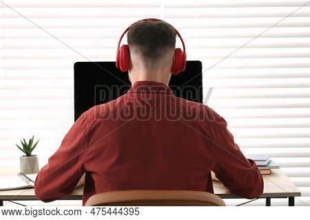Man In Headphones Studying On Computer Indoors, Back View. Online Translation Course