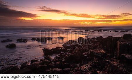Sunrise View Of A Calm Wave Cut Platform With Rocks And Reflections, Long Exposure.