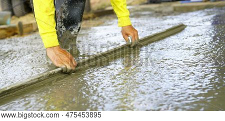 Construction Worker Leveling Wet Concrete Floor With A Trowel At Construction Site. Construction Wor