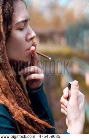 Young Pretty Girl Teenage With Dreadlocks Outside Smoking Cigarette, Looking Like Real Junky, Social