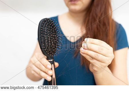 Cropped Long Haired Ginger Woman In Blue Tshirt Presenting Hair Comb With Hair To Camera, Showing Ha