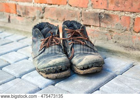 The Concept Of Poverty, Homelessness, Lack Of Money. Dirty Old Shoes On Paveng Floor. A Pair Of Dirt