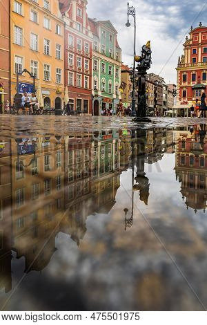 Wroclaw, Poland - July 2022: Wroclaw Market Square Old Tenement Houses Reflected In Small Puddle