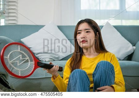 Asian Female Sitting Floor Using Mosquito Device Swatter Or Electric Net Racket, Young Woman Killing