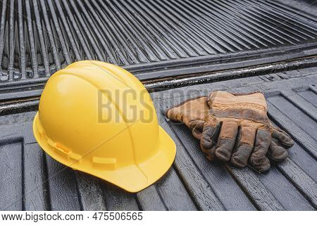 Hardhat And Work Gloves During A Wet Day On Pickup Truck Bed
