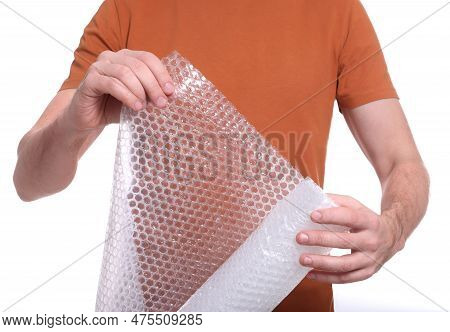 Man Holding Roll Of Bubble Wrap On White Background, Closeup. Stress Relief