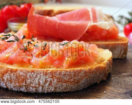 Close-up Of Spanish Tapas On Wooden Board. Toasted Bread Rubbed With Fresh Garlic And Ripe Tomato, T