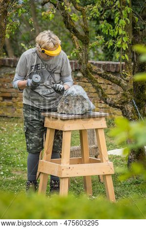 Sebastiano Da Po, Italy - April 12 2023: Woman Carving A Stone During An Outdoor Sculpture Lesson Or