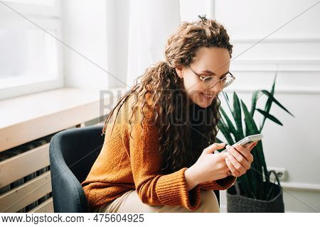 Happy Woman Browsing Modern Apps On Mobile Phone Relaxed Woman Using Cellphone For Online Shopping Y
