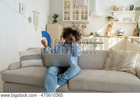 Overheating. Tired Black Woman Suffers From Stuffiness And An Inoperative Air Conditioner, Waving Bl