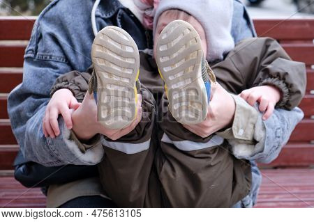 The Child Put The Shoes On The Wrong Foot, Instead Of The Right On The Left. Kid Aged About Two Year