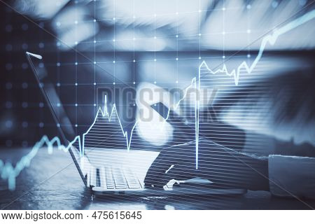 Close Up Of Hands Using Laptop Kyeboard And Cellphone With Growing Blue Financial Forex Chart On Blu