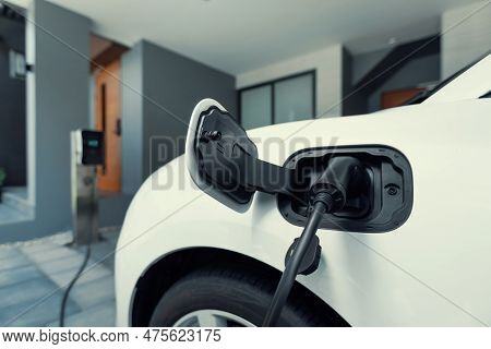 Closeup Electric Vehicle Plugged-in With Cable From Charging Point Powered For Progressive Concept B