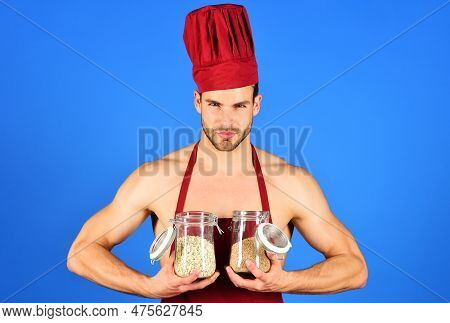 Breakfast And Healthy Food. Sexy Male Chef With Serious Face In Burgundy Hat And Apron Holds In Hand